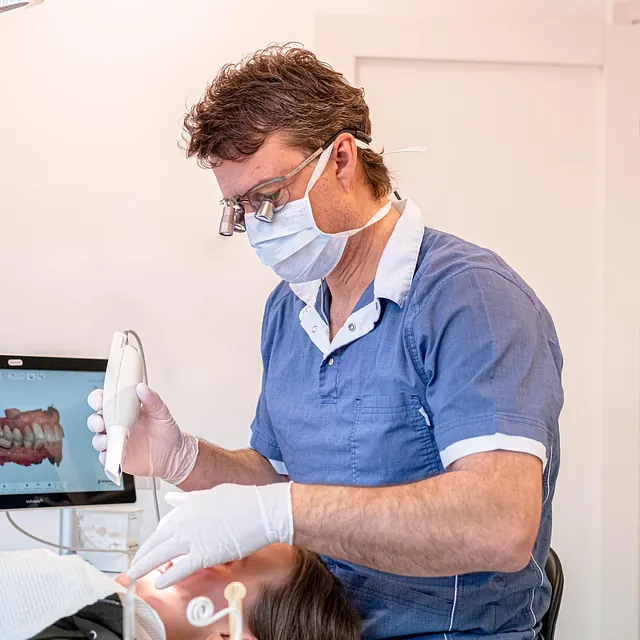Tannlege utfører behandling av pasient i en moderne tannklinikk.